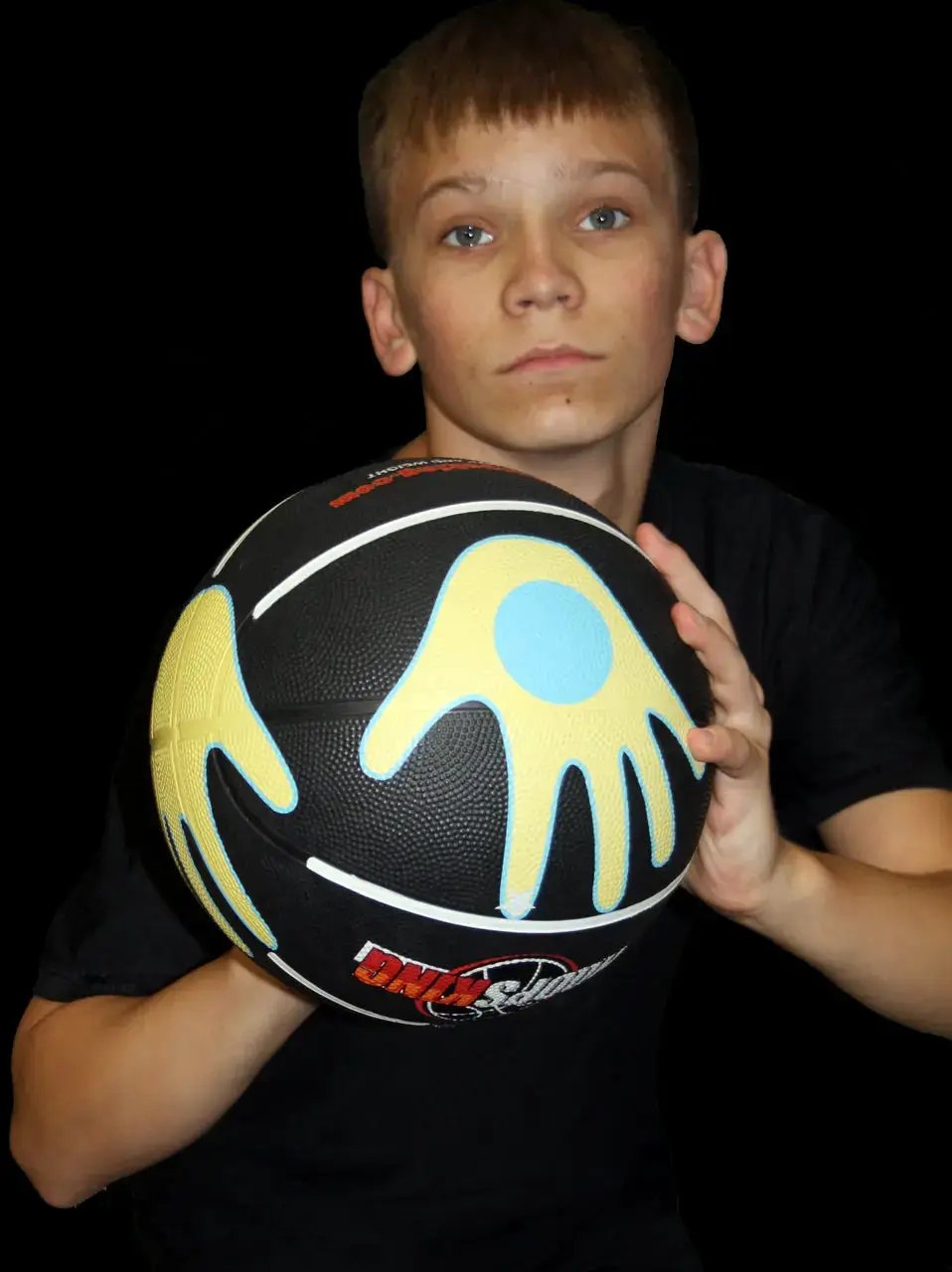 Hands on Shooter Basketball with Hand Placement; black ball with yellow abstract pattern and blue accent.