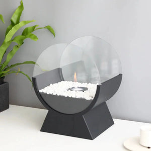 13.5-inch tall portable tabletop fireplace by JHY DESIGN with round glass guard, black base, and white stones