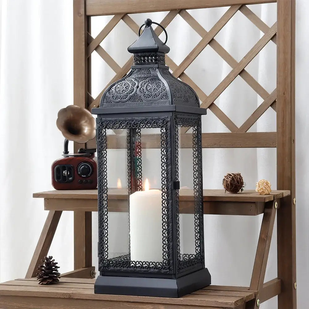 19-inch high rustic black metal candle lantern with glass panels and ornate filigree, candle inside