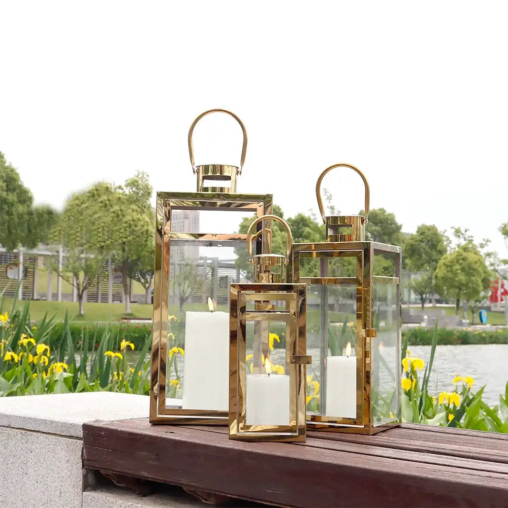 Set of 3 gold-toned stainless steel decorative candle lanterns with glass panels
