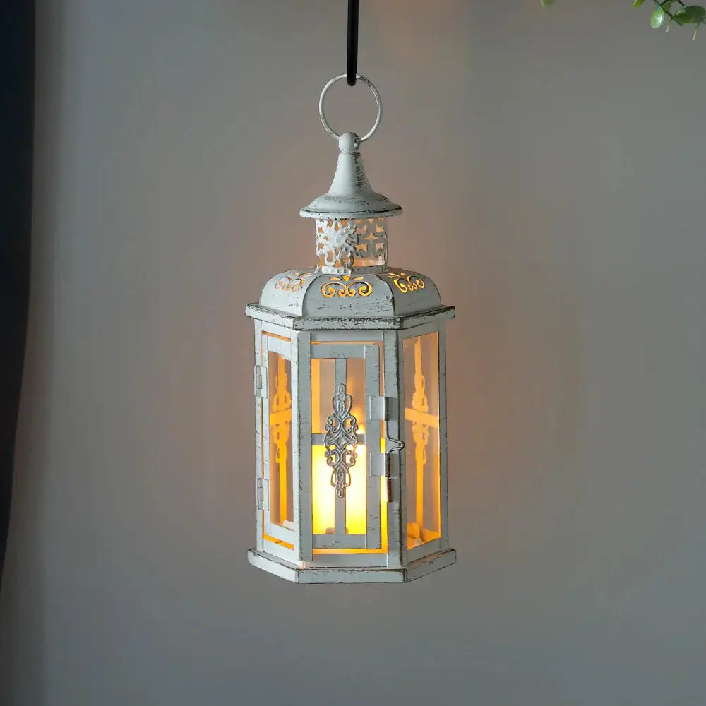 10-inch vintage-style hanging metal lantern candleholder in distressed white with a warm candle glow