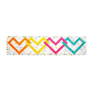 Linked Hearts Quilted Table Runner Kit by Block Party Quilt Co, colorful diamond-heart pattern on white background.