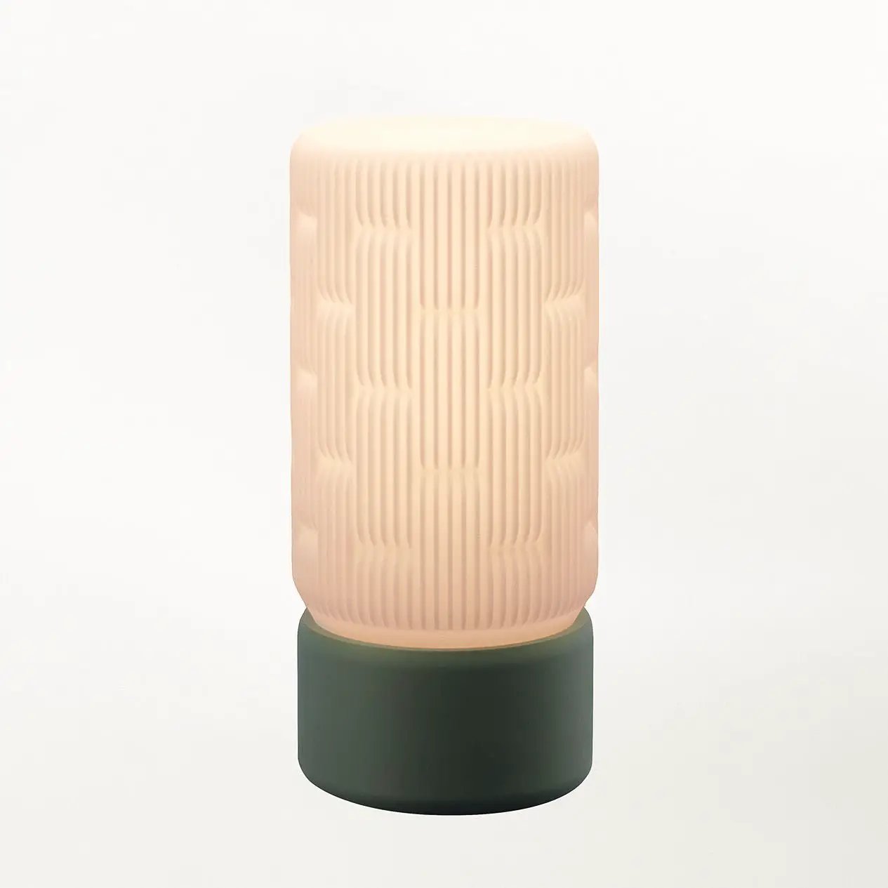 Liunk Table Lamp by Terra Labs with peach ribbed shade and dark green base.