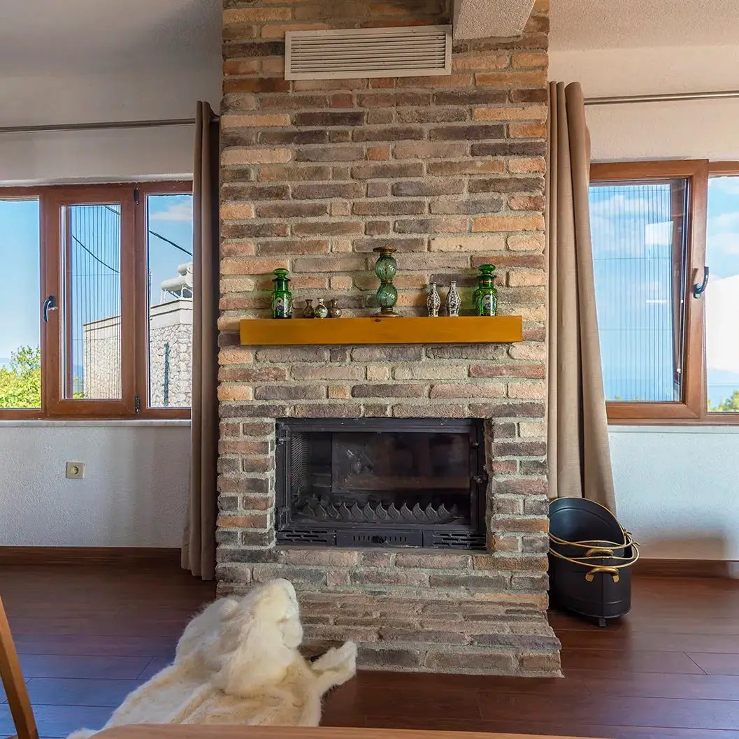 Ferrara Old School brick veneer fireplace surround with warm brick tones and wooden mantel in living room