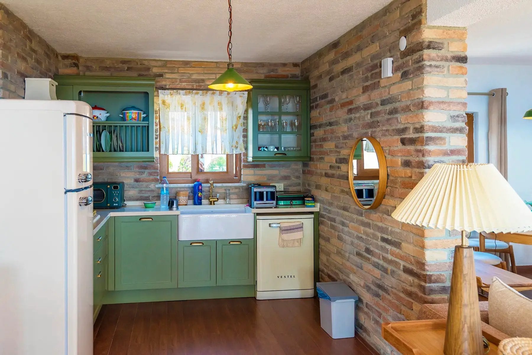 Ferrara Old School brick veneer in a kitchen with green cabinetry; handmade stone look.