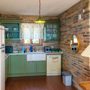 Ferrara Old School manufactured stone brick veneer in warm earthy tones on a kitchen brick wall