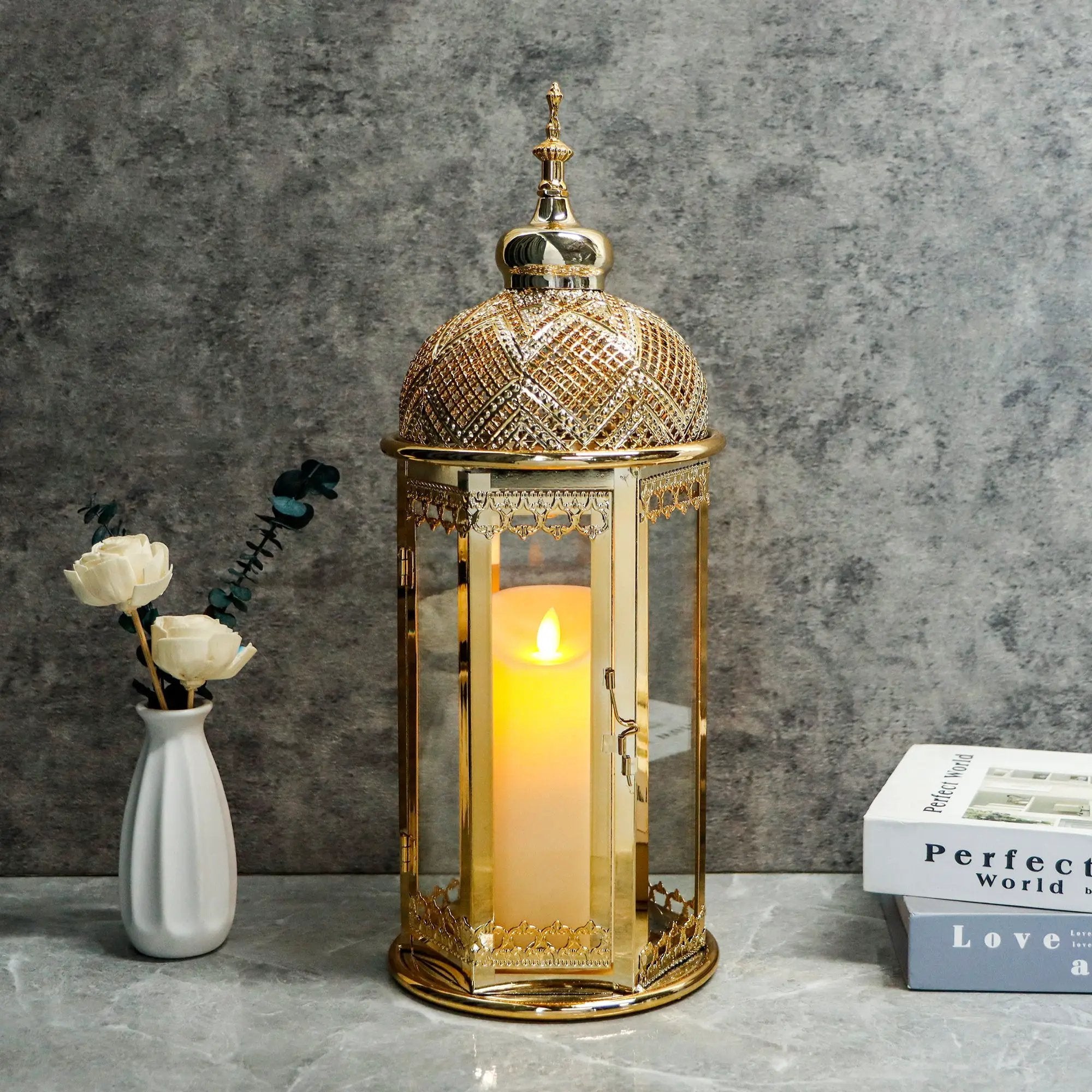 Moroccan candle lantern, 15-inch gold hexagonal metal lamp with glass panels and lit candle.