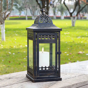 Decorative candle lanterns set of 3, black metal with glass panels and a white candle inside.