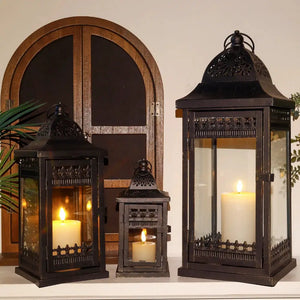 Decorative Candle Lanterns set of 3 by JHY DESIGN; black metal lanterns with glass panels in 9.5, 14.5, and 20 inches, with lit candles.