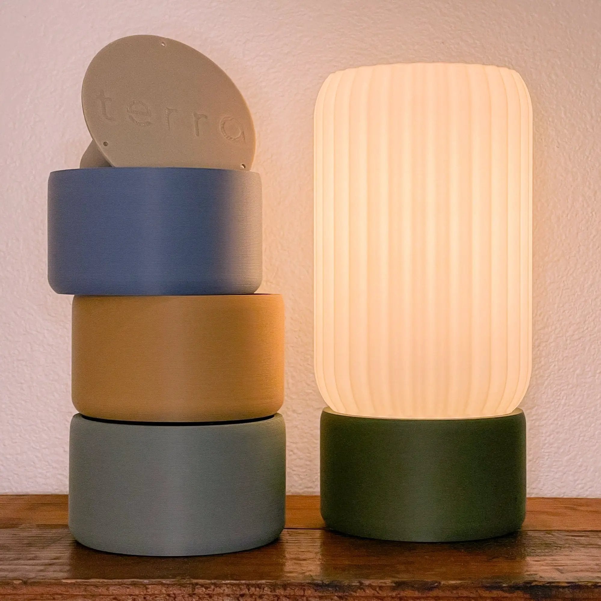 Milk Shade Barrel Table Lamps by Terra Labs; two stacked barrel bases in blue-gray and tan, with an ivory ribbed shade on the right
