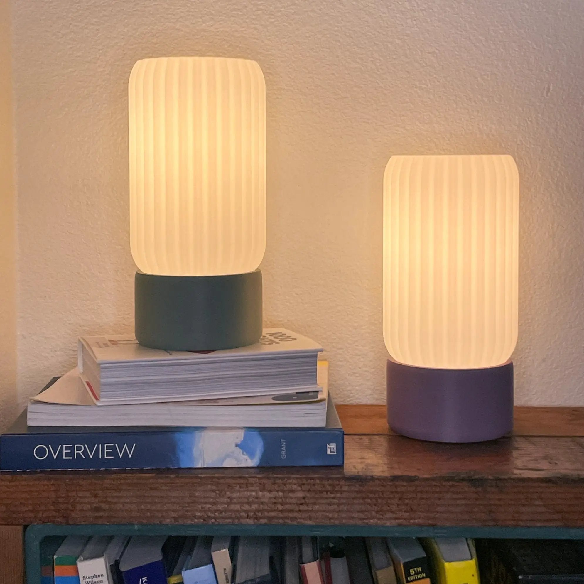 Milk Shade Barrel Table Lamps by Terra Labs, pair with ribbed cream shades on dark teal and purple bases.