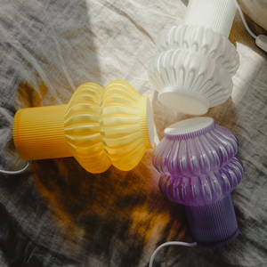 Oppi table lamp pieces in yellow, white, and purple ribbed glass.