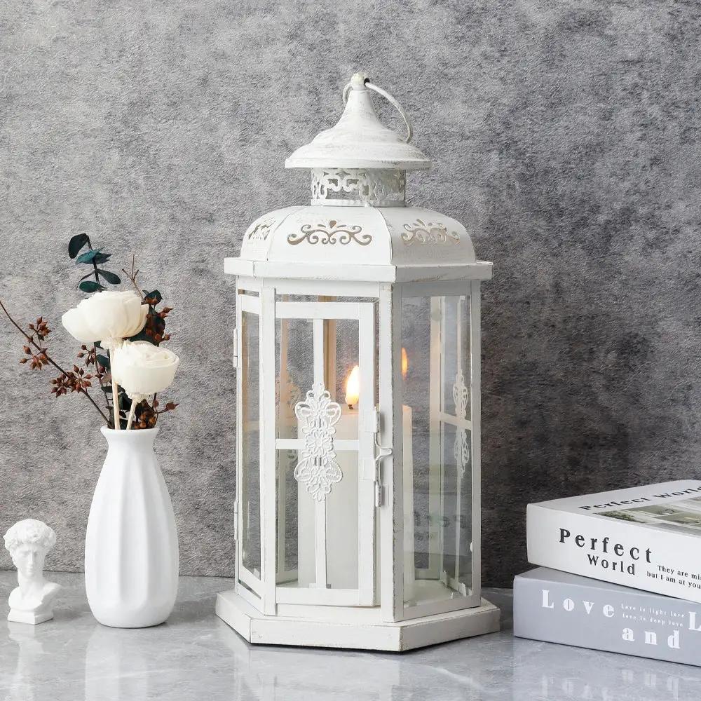 12-inch white decorative candle lantern with gold brush finish, glass panels, lit candle inside