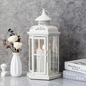 12-inch white decorative candle lantern with gold brush finish, glass panels, lit candle inside