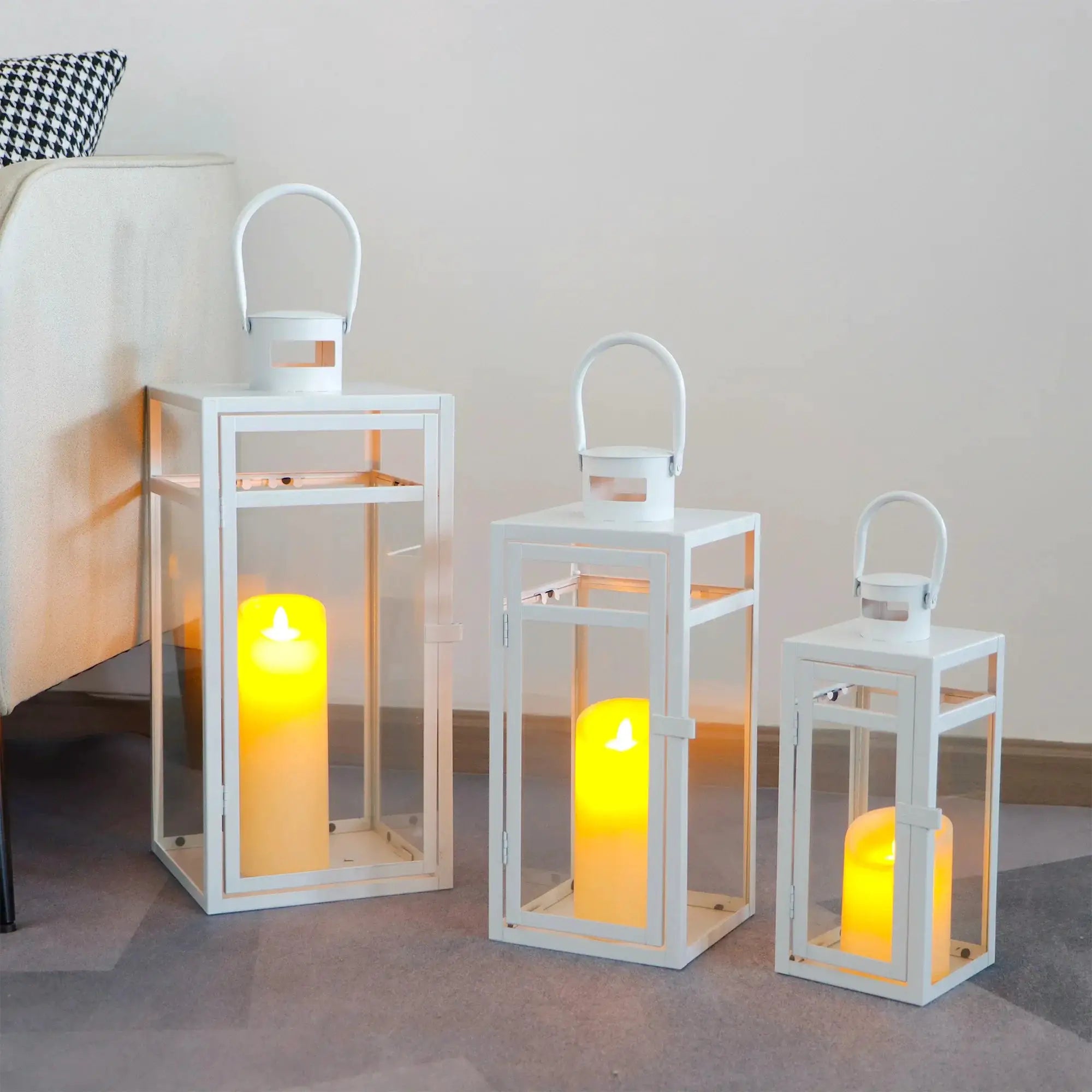Set of 3 white metal candle lanterns with glass panels and arched handles (12/15/19 in).