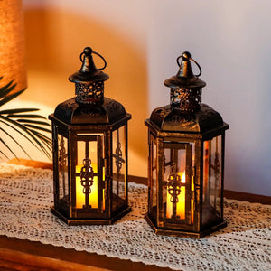 10-inch high vintage-style hanging lanterns set of 2 in black metal with warm candlelight.