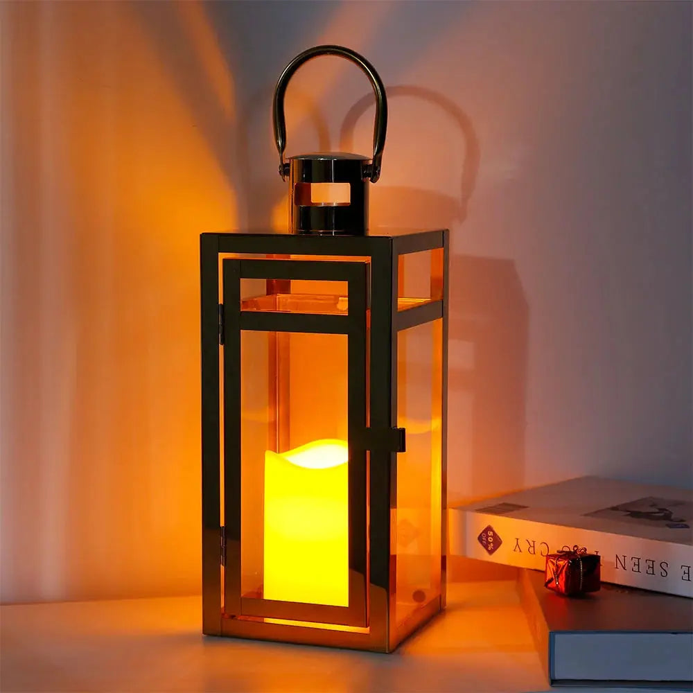 12'' High gold metal decorative candle lantern with glass panels and hanging handle.