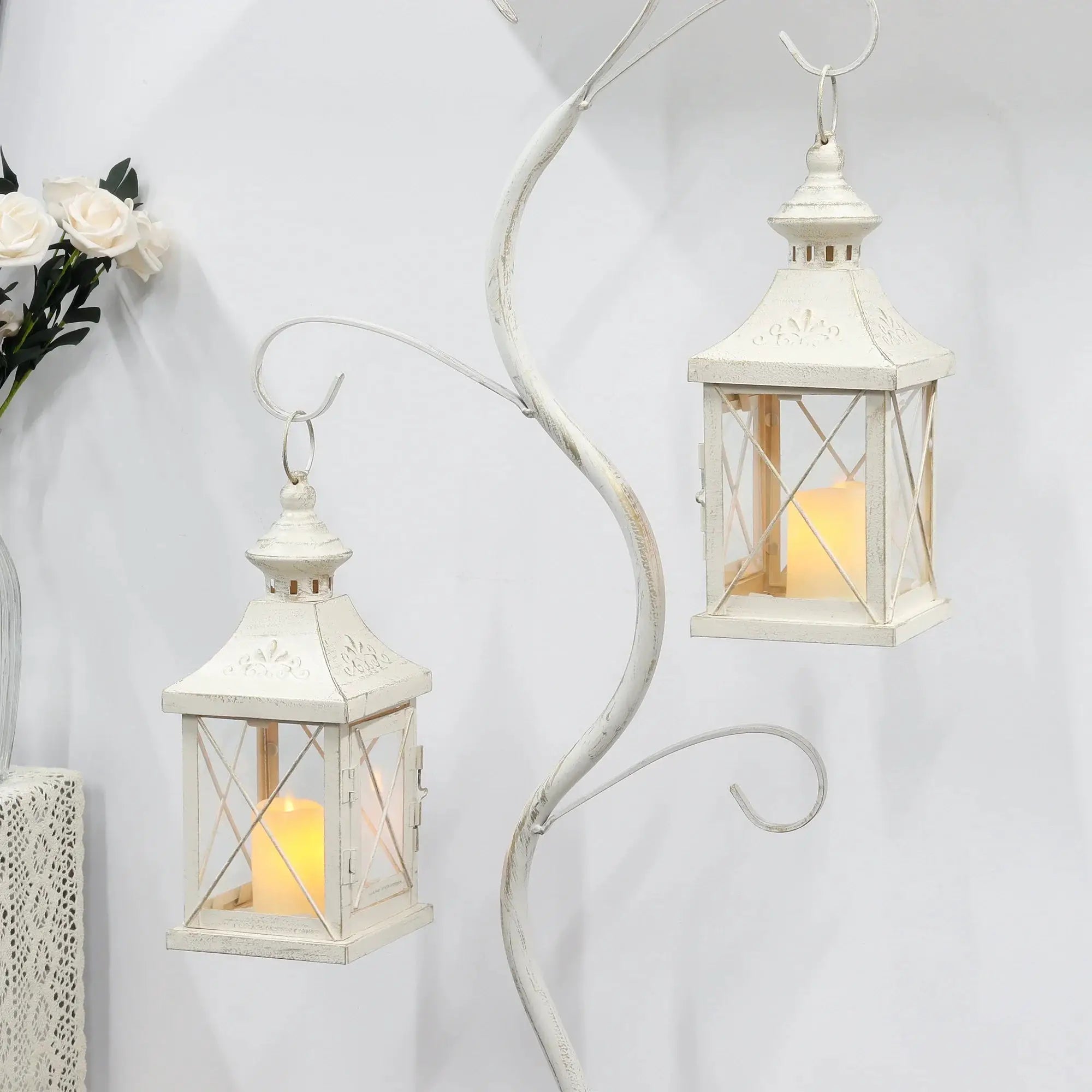 Set of 2 white distressed 11in decorative candle lanterns with glass panes and glowing candles.