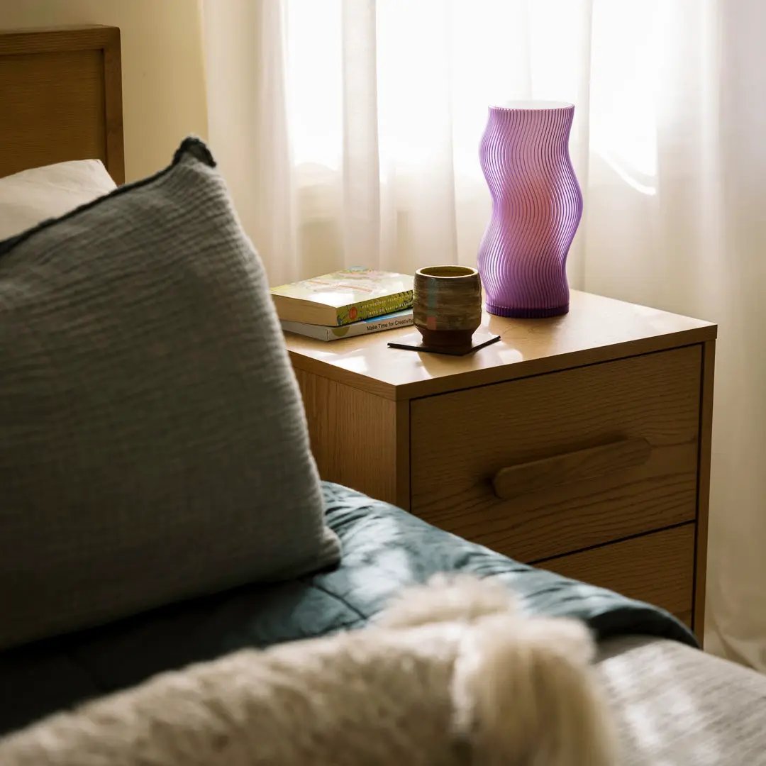Woogie Table Lamp by Terra Labs; purple wavy glass design on a wooden nightstand.