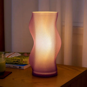Woogie table lamp with purple gradient ribbed curved glass and warm glow on a wooden table.
