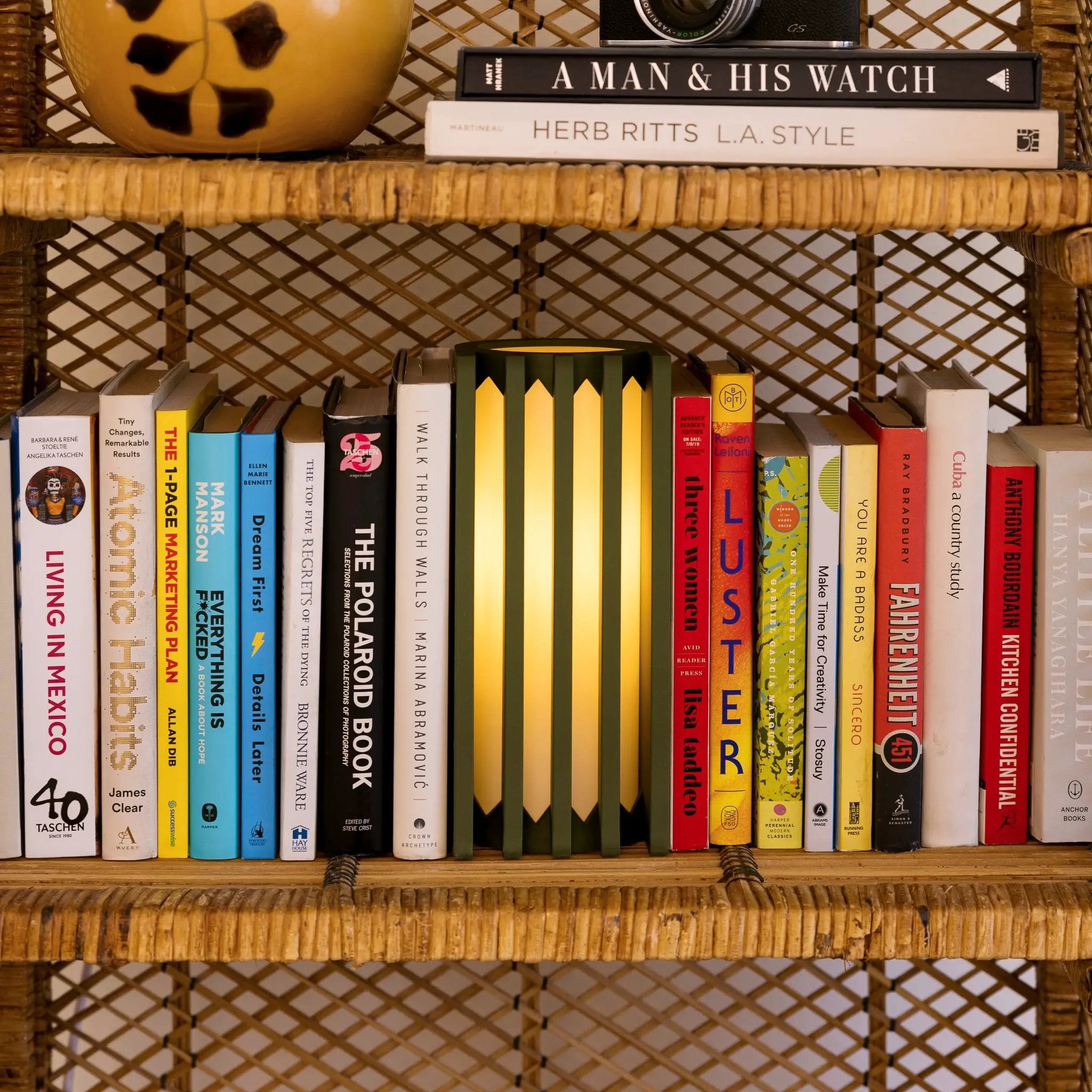 Radiator Table Lamp by Terra Labs, green base with yellow shade on a book-filled shelf