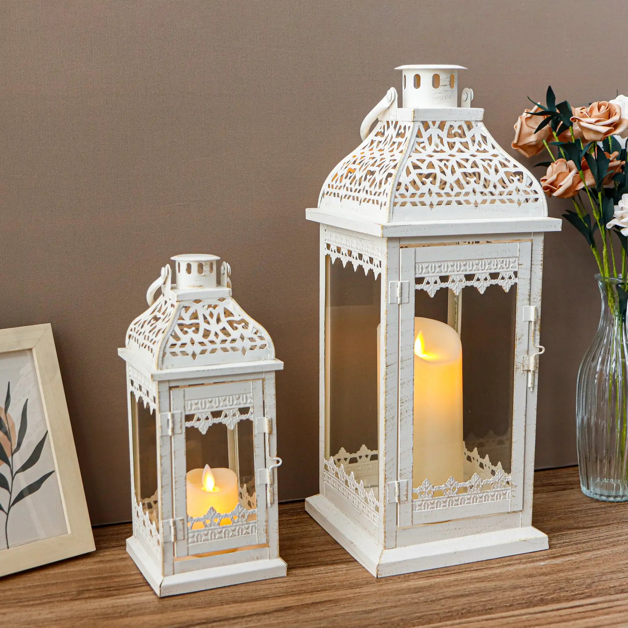 Set of 2 decorative candle lanterns, 13 and 19.5 inches tall, white distressed metal with lattice panels.