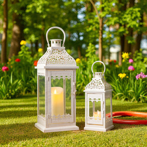 Set of 2 decorative candle lanterns with beige-gold brush finish, vintage metal lattice design in a garden.