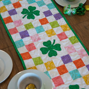 Shamrocks Rainbow Table Runner Quilt Kit by Block Party Quilt Co; rainbow patchwork with green shamrock centerpiece
