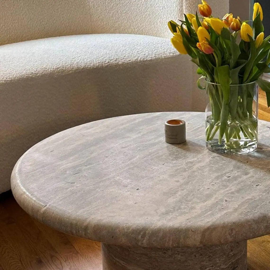 Villohome silver travertine vein-cut round coffee table, 36in dia x 16in high, with vase of yellow tulips