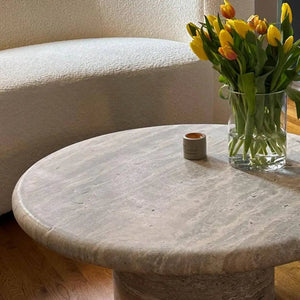 Villohome silver travertine vein-cut round coffee table, 36in dia x 16in high, with vase of yellow tulips