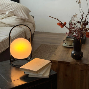 2600mAh portable waterproof rechargeable table lamp with black metal frame and warm glow on a wooden table