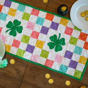 Quilt Kit: Seasonal table runner with multicolor patchwork and green border by Block Party Quilt Co
