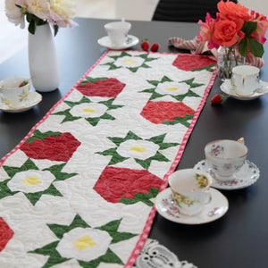 Strawberry Table Runner Pattern by Block Party Quilt Co; home decor sewing pattern in red, white and green floral colors.