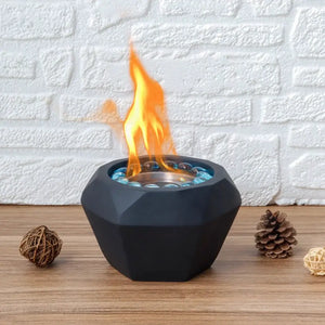 6x4in portable cement tabletop fireplace with a faceted black base and blue glass beads, flames rising