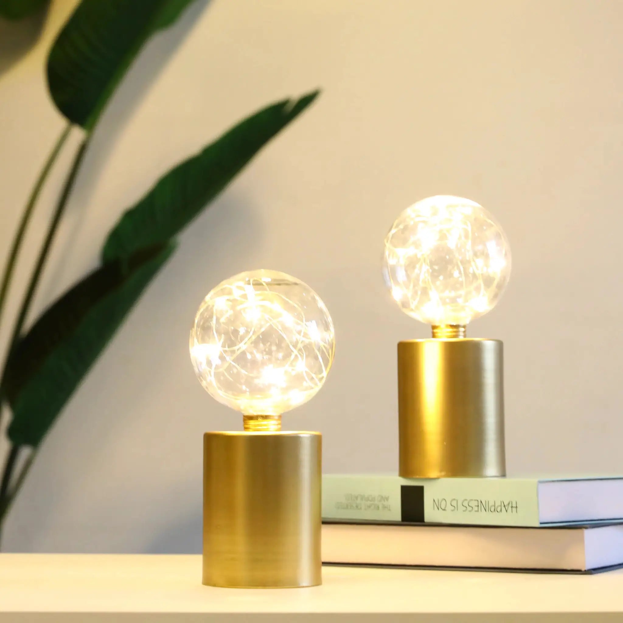 8-inch tall gold battery-powered table lamps, set of 2, with clear glass globe bulbs.
