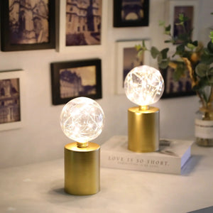 8-inch tall gold battery-powered table lamps, set of 2, with clear glass globe bulbs.