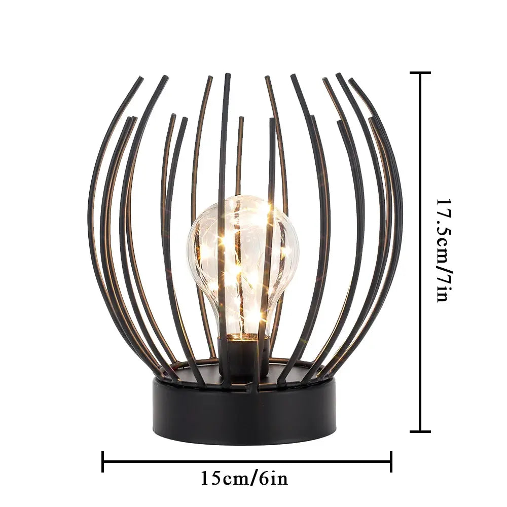 7-inch tall battery-powered table lamp with a black metal wire sphere around a clear bulb.