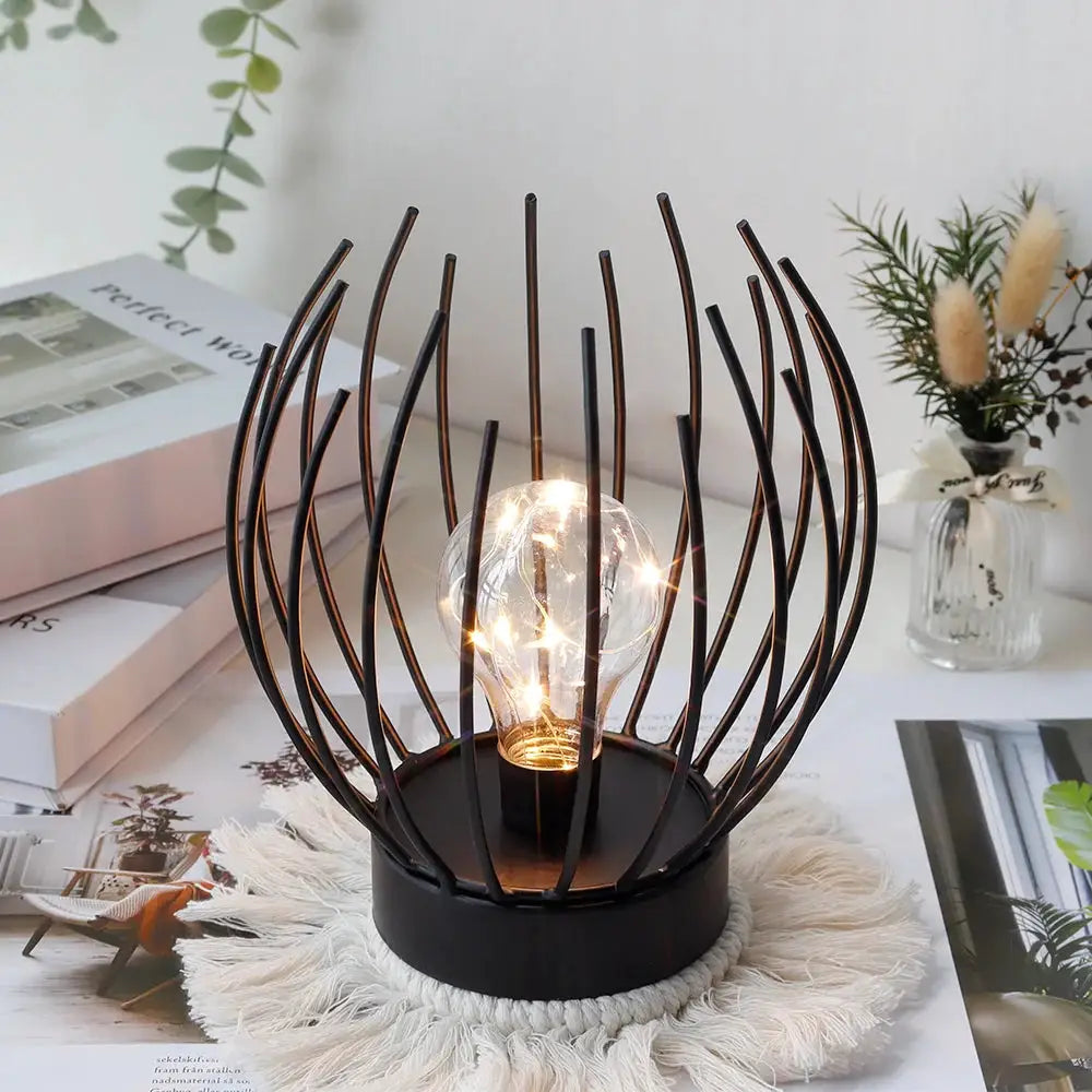 7in tall battery-powered table lamp by JHY DESIGN; black metal orb cage with warm LED bulb