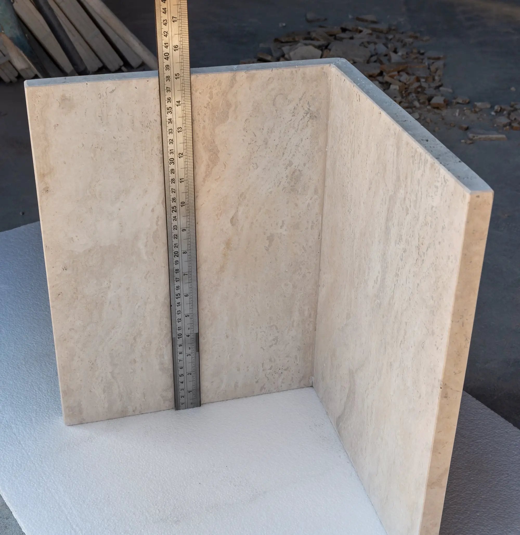 Troia Light travertine coffee table slab in beige with ruler for scale on a construction site