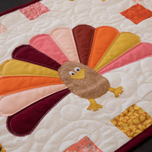 Quilt kit Turkey Thanksgiving table runner with backing by Block Party Quilt Co, colorful autumn feather design