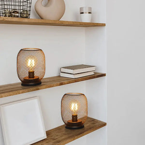Set of 2 battery-operated LED egg-shaped table lanterns with dark metal wire-mesh cages on wooden shelves