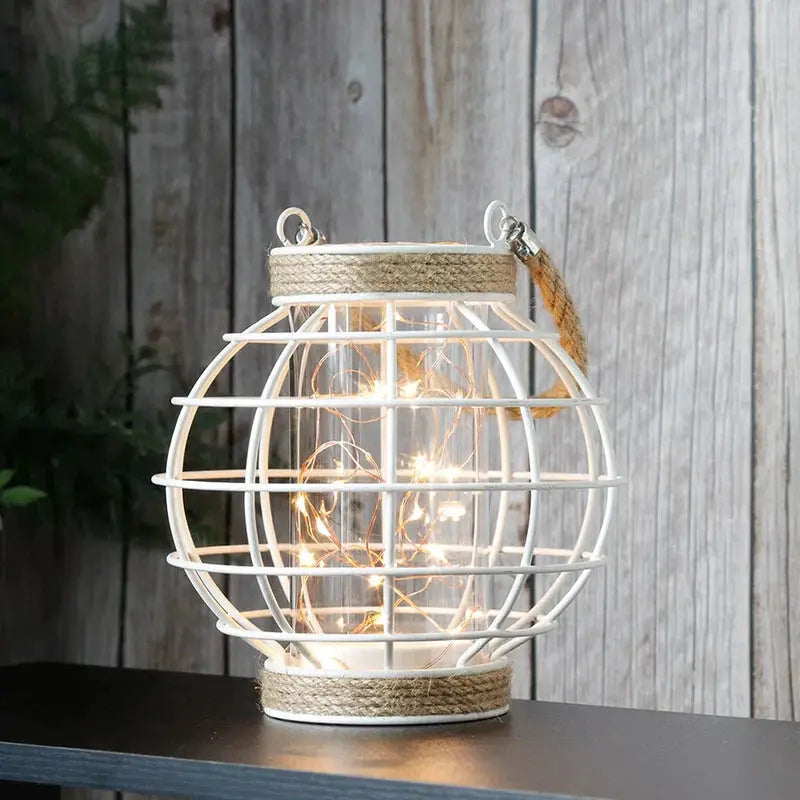 White metal cage LED lantern, 7.3in tall, battery-powered with warm string lights by JHY DESIGN