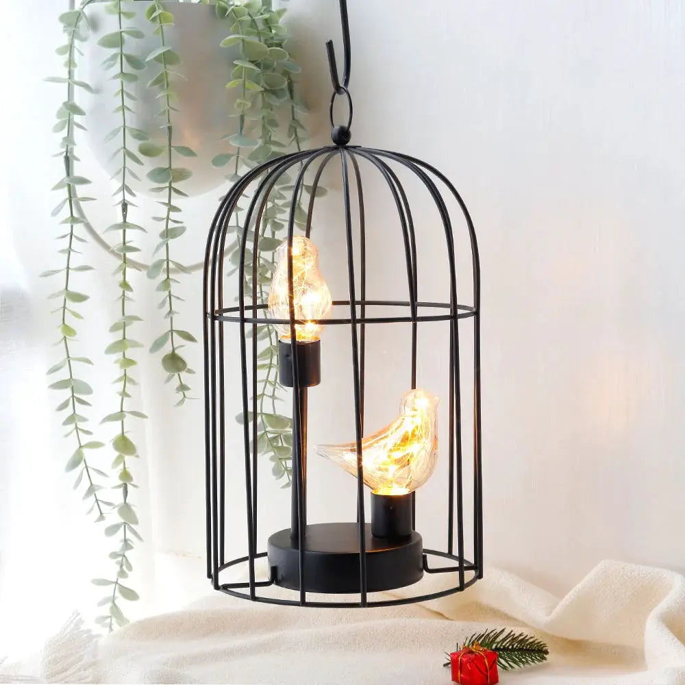 12-inch tall battery-operated birdcage lamp with two bird-shaped light bulbs inside; black metal cage by JHY DESIGN