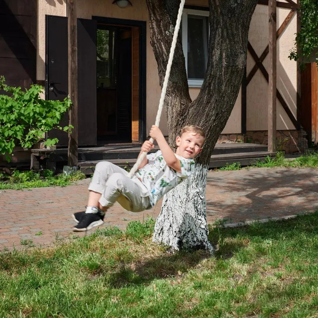 Wooden rope swing for kids, a single swing hanging from a tree in a sunny backyard