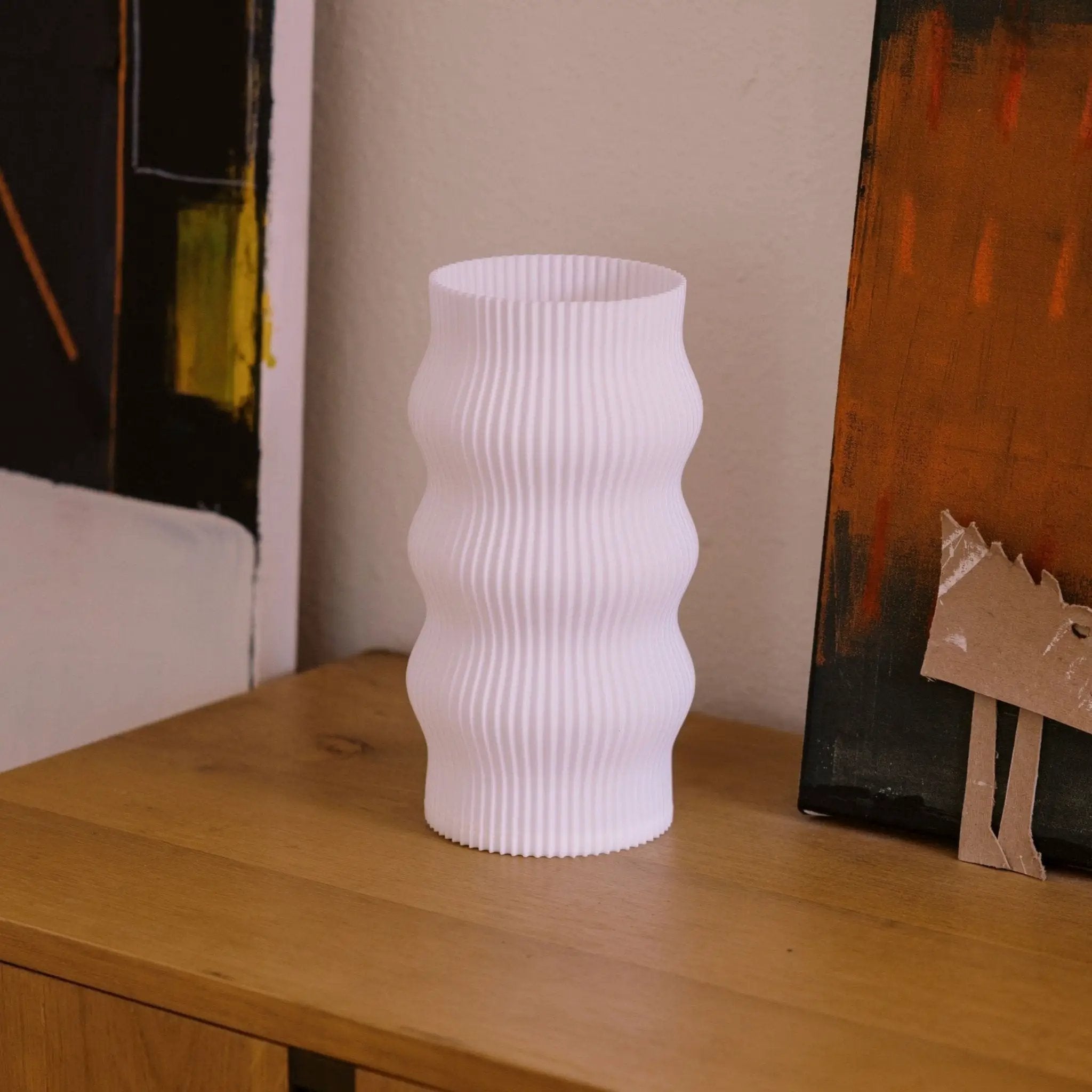 Wub Table Lamp; white ribbed ceramic body with cloud-inspired curves on a wood surface.
