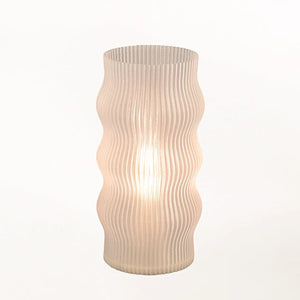 Yuji table lamp by Terra Labs featuring a ribbed, curved pale pink glass shade